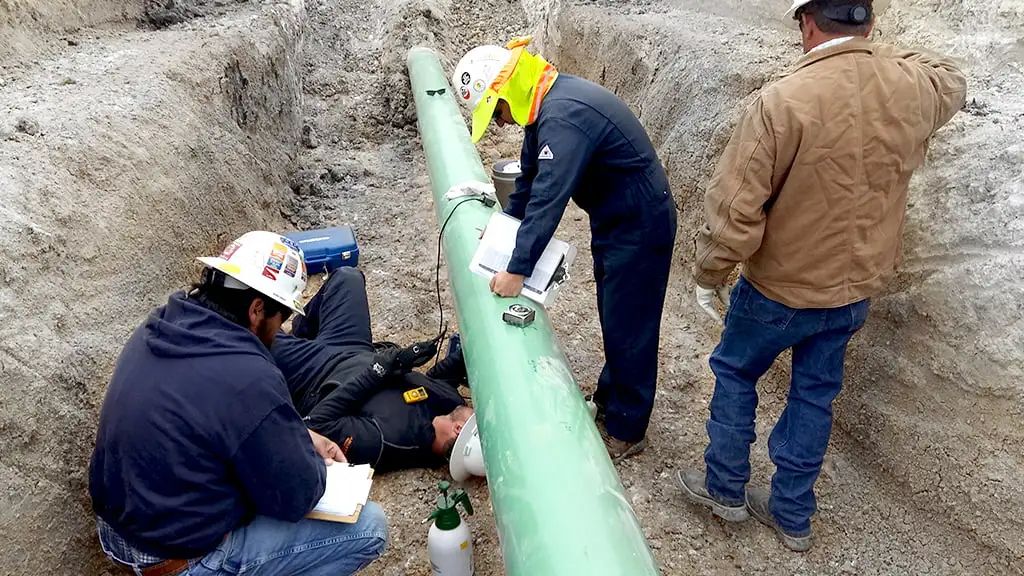 Several people installing corrosion monitoring in a pipeline in the Middle East. Picture.